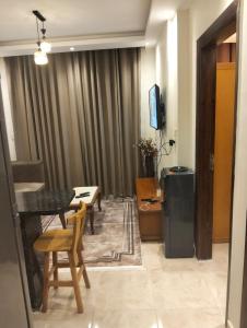 a living room with a table and chairs and a television at شاليه بجولف بورتو مارينا للأسر فقط in El Alamein
