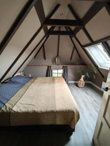 a bedroom with a bed in the attic at Vakantiehuisje 'De Uithof' in Oosterhesselen