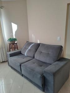 a grey couch in a living room with a table at Apartamento no Centro de Brusque/SC in Brusque
