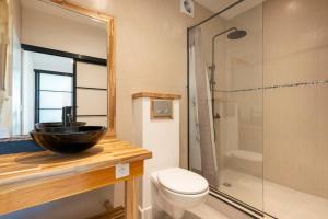 a bathroom with a sink and a toilet and a shower at TERA ORA TORU - Lodge and sea view in Papeete