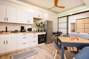 a kitchen with white cabinets and a table and a dining room at TERA ORA TORU - Lodge and sea view in Papeete