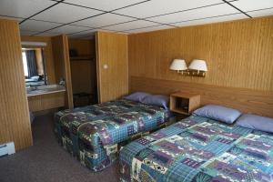 a hotel room with two beds and a sink at Malta Edgewater Inn and RV Park in Malta