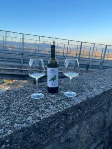 a bottle of wine and two wine glasses on a wall at La Rosa Blu in Gerace