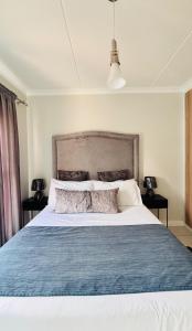 a bedroom with a large bed with a blue blanket at The Blyde Crystal lagoon Pretoria in Pretoria +121 photos
