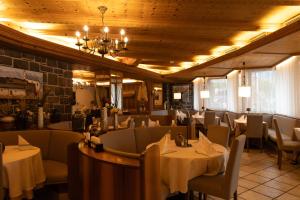 ein Restaurant mit Tischen und Stühlen in einem Raum in der Unterkunft Hotel Marlingerhof in Marling