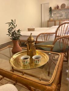 a glass table with two cups on a tray at Sukoun Studios in Baalbeck