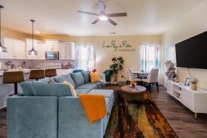 a living room with a blue couch and a kitchen at Family-Friendly 3BR w Hot Tub Games in Charlotte