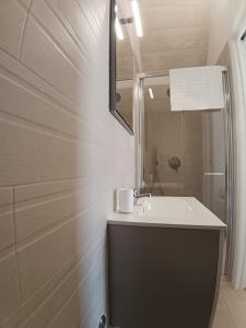 a white bathroom with a sink and a mirror at villa mastroronzo in San Michele Salentino