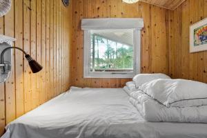 a bed in a wooden room with a window at 873-Thisted-Blamunkevej-67 in Thisted