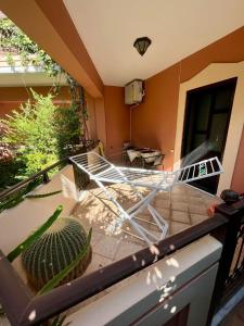 a balcony with a chair and a cactus at Rosmarino in Kissamos