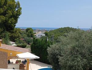 a house with an umbrella and a swimming pool at Chalet con piscina privada in Las Villas