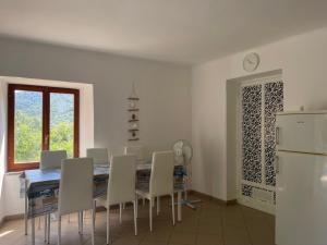 a dining room with a table and chairs and a refrigerator at A 2 Colli dal Mare in Varazze
