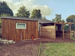 a large wooden building with a gazebo at Bewley Glamping in Wambrook