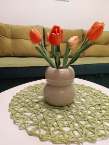 a vase with red tulips in it on a table at Stancicmilena in Požarevac