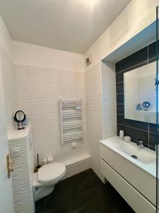 a white bathroom with a toilet and a sink at Beausoleil near Monaco - Cosy Studio with Sea view in Beausoleil