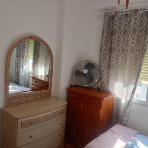 1 dormitorio con espejo, tocador y ventilador en Rooms Malaga, en Málaga