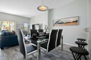 a dining room with a table and chairs and a couch at Quiet Resort 3BR • Nature Walk • 20min to Disney in Kissimmee