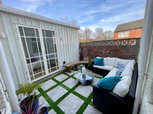 a patio with a couch and a table at Hidden Gem in cullercoats in Cullercoats