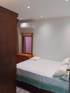a bedroom with a bed with a dresser and a window at شاليه بجولف بورتو مارينا للأسر فقط in El Alamein