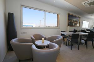 a dining room with chairs and a table and a window at Hôtel Restaurant les Pielettes in Le Rove
