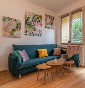 a living room with a green couch and a table at Apartament HoliStay in Oświęcim