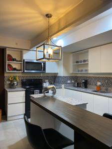 a kitchen with a wooden counter top and a chandelier at Exclusive apartment in downtown Costa Rica in San José