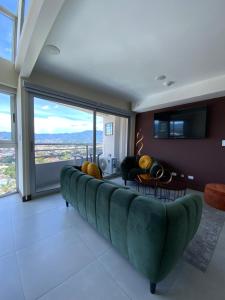 a large couch in a living room with a large window at Exclusive apartment in downtown Costa Rica in San José