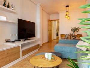 a living room with a blue couch and a tv at Dream Costa Blanca Luxury Apartment in Torrevieja