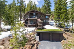 une maison dans les bois avec un garage dans l'établissement Alpine Retreat By Hauserman Rentals, à Tahoe City