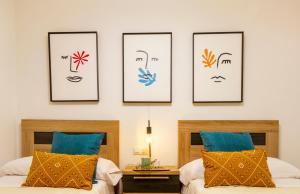 two beds in a bedroom with four pictures on the wall at Dream Costa Blanca Luxury Apartment in Torrevieja