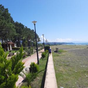 a person walking down a path near the beach at Ferienhaus in Georgien, Kobuleti in der Nähe vom Strand in K'obulet'i