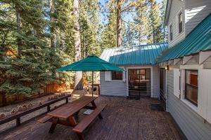 - une terrasse avec une table de pique-nique et un parasol dans l'établissement Fir Forest Cottage By Hauserman Rentals, à Tahoe City