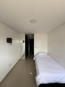 two beds in a room with white walls at Casa Seganis in Bogotá
