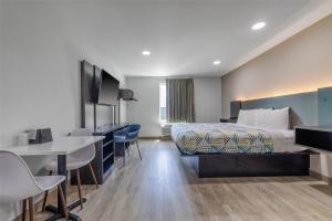 ゴンザレスにあるMotel 6 Gonzales, LA Baton Rouge Geismar Prairieville I 10のベッドと机があるホテルの部屋