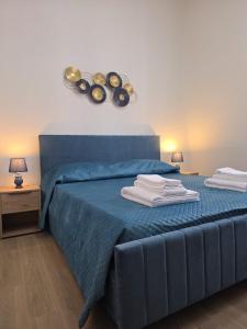 a bedroom with a blue bed with towels on it at La Maison dello Stretto in Messina