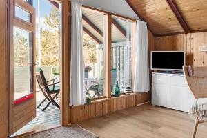 a living room with a television and large windows at 1024-Thisted-Lars-Badskjaers-Sti-2 in Torsted