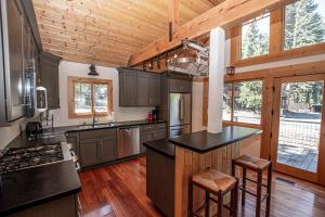 una cocina con encimeras negras y techos de madera. en Bonanza By Hauserman Rentals, en Tahoe City