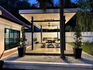 Un patio con una mesa y árboles en una casa. en B52 Pool Villa Pattaya, en Pattaya South