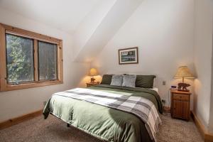 a bedroom with a bed and two lamps and a window at Celtic Lodge By Hauserman Rentals in Homewood