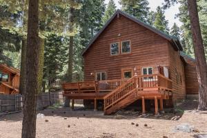 a log cabin with a large deck in the woods at Celtic Lodge By Hauserman Rentals in Homewood