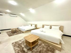 Un dormitorio con dos camas y una mesa dentro. en B52 Pool Villa Pattaya, en Pattaya South 33 fotos más