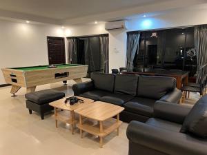 Una sala de estar con un sofá y una mesa de billar. en B52 Pool Villa Pattaya, en Pattaya South