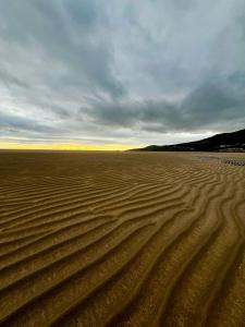 a desert with tracks in the sand under a cloudy sky at Rose Cottage in Killybegs +11 photos
