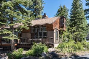 a house with a large deck in the woods at Dollar Hill II # 49 By Hauserman Rentals in Tahoe City