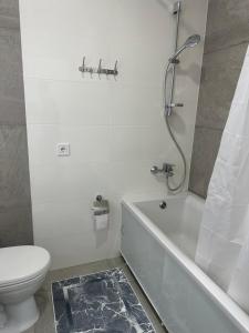 a white bathroom with a toilet and a shower at Студия с Видом на Море, 9-2 in Chornomorsk