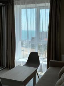 a room with a chair and a large window at Студия с Видом на Море, 9-2 in Chornomorsk