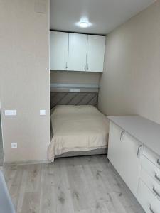 a small bedroom with a bed and white cabinets at Студия с Видом на Море, 9-2 in Chornomorsk