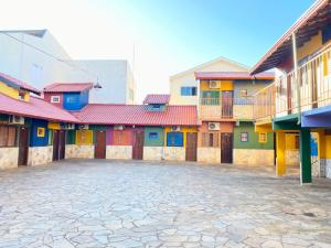 a row of colorful buildings with a courtyard at Hotel Pousada Mozini's in Tupã