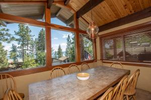 a dining room with a table and chairs and windows at Coates By Hauserman Rentals in Tahoe City