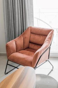 a brown leather chair in a room with a window at Manda Ray Seafront Apartment Endless Blue View in Perea